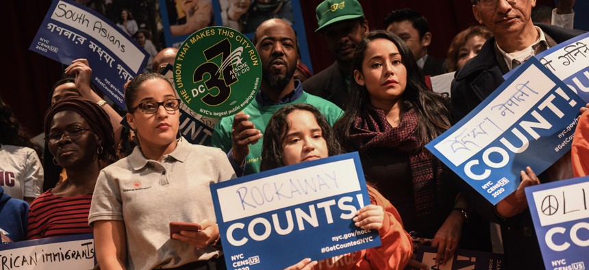 Community members hold signs encouraging participation in the 2020 Census at a rally in New York City.