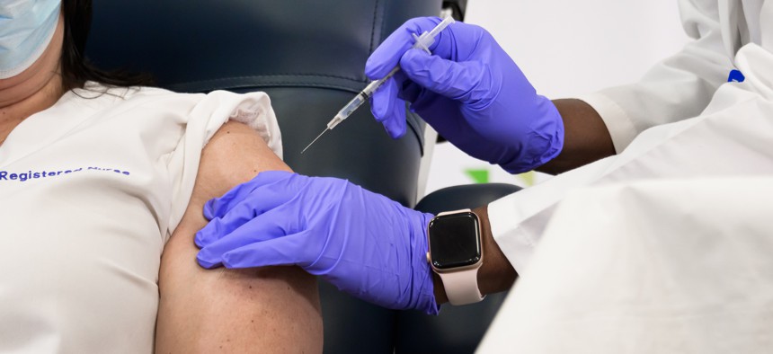 Medical worker administers a COVID-19 vaccine dose at the Long Island Jewish Medical Center.