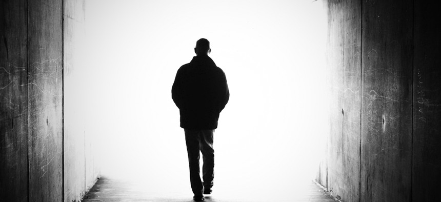 A silhouette of a man walking in darkness
