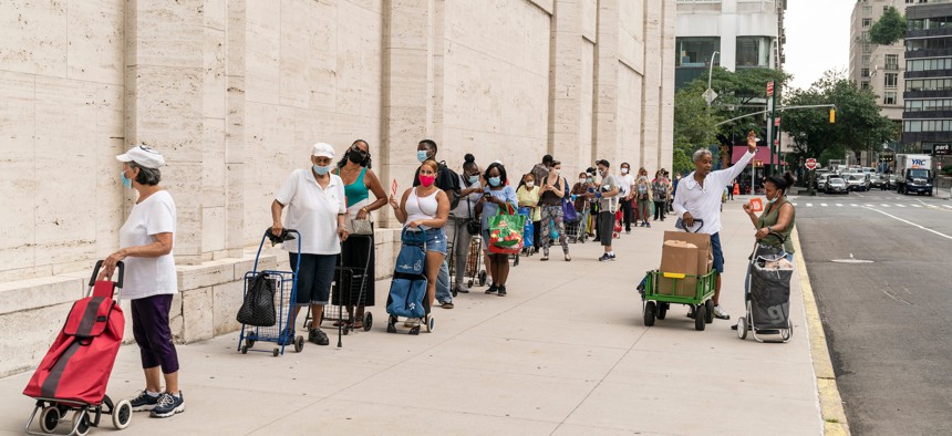 People wait in line at a food distribution site in Manhattan in July 2020.