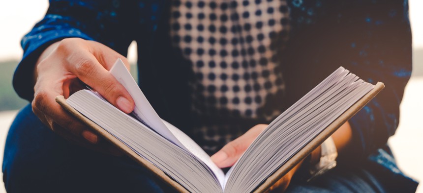 A man reads a book. Maybe it is New York Law School Professor Lenni Benson's new book about child migrants