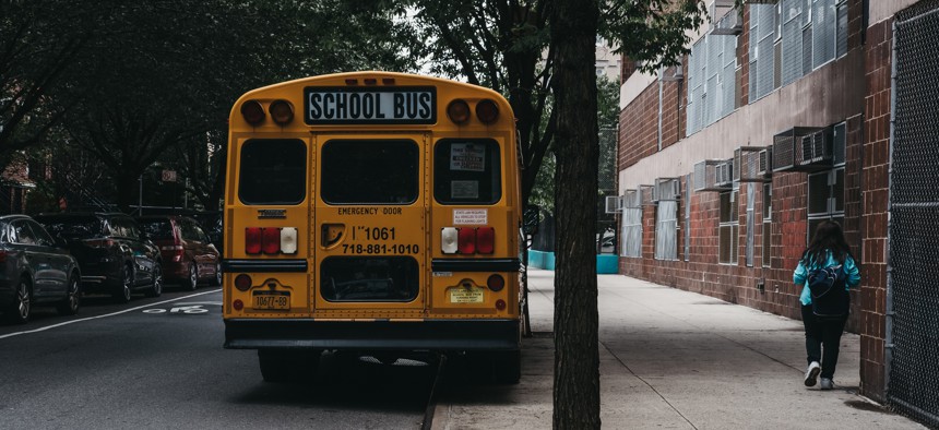 A student walks by a school bus in New York City.