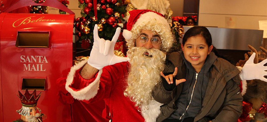 Deaf Santa does sign language with a child