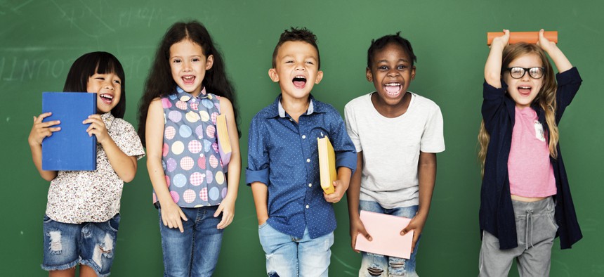 Children standing in front of a green wall