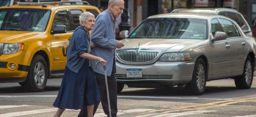 An older couple crosses a New York City street.