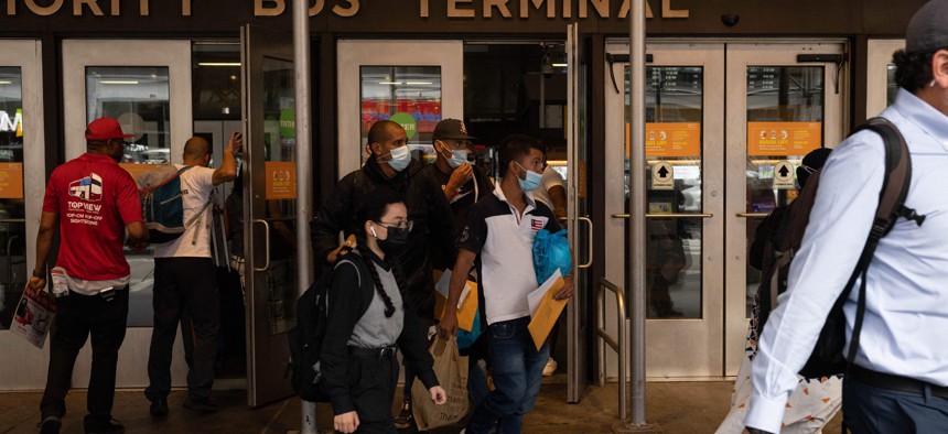 A group of migrants walks out of Port Authority Bus Terminal after their bus arrived from Texas on August 10, 2022 in New York. - Texas has sent thousands of migrants from the border state into Washington, DC, New York City, and other areas. (Photo by Yuki IWAMURA / AFP) 