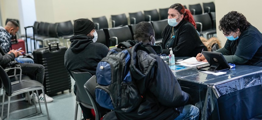 Asylum-seekers speak with support services workers at the Brooklyn Cruise Terminal in Red Hook last month. 