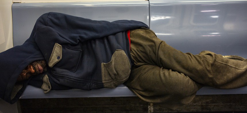 A man sleeps on a subway seat on a west bound train in Brooklyn, New York. 