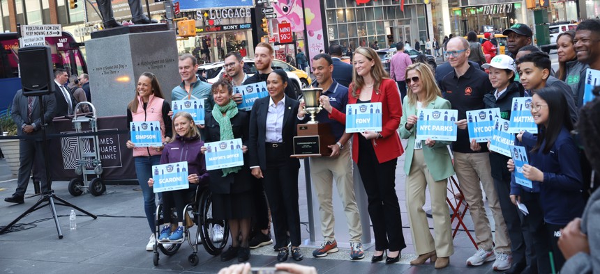 New York Road Runners CEO Rob Simmelkjaer poses with representatives from 8 public service agencies and the mayor’s office competing in this year’s Commissioner’s Cup at a press conference in Times Square Thursday.