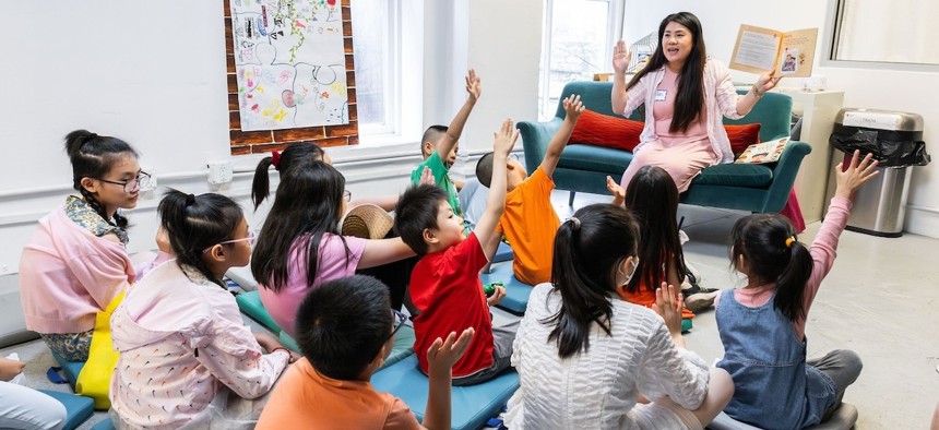 An Apex volunteer reads to young children during this year's book fair. Photo by Clara Hung for Apex for Youth.