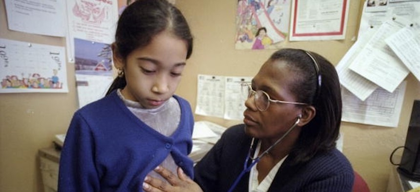 New York City public school nurse Gloria Henderson supervises Nicole Davila's pump medication in the nurse's office at Public School 48.