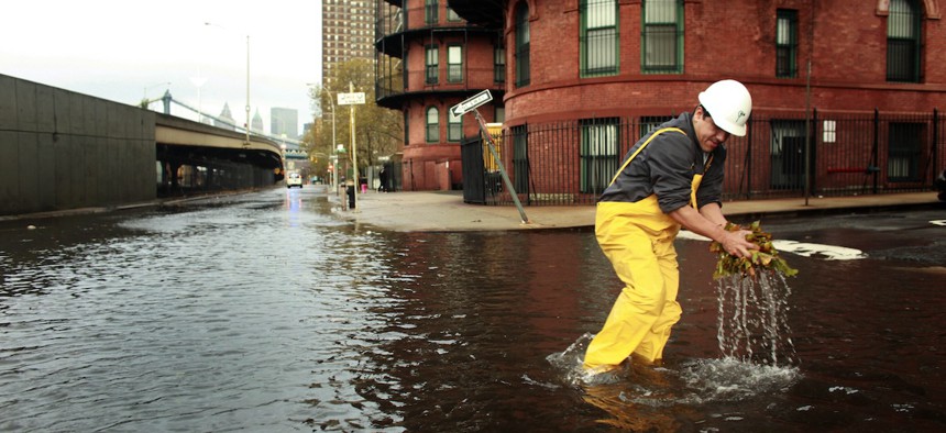 A man clears leaves from a sewer drain in lower Manhattan on October 30, 2012 in New York City after Hurricane Sandy, which caused massive flooding across much of the Atlantic seaboard.