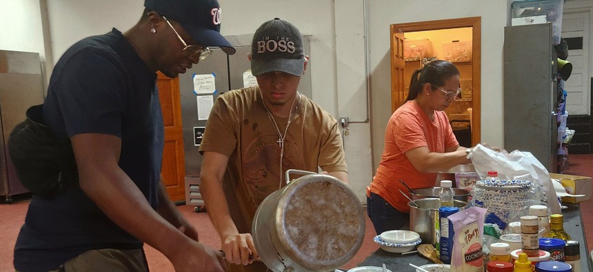 Migrant volunteers prepare a to-go meal of beans and rice as part of the food program run by the nonprofit Artists Athletes and Activists at Metro Baptist Church in Manhattan’s Hell’s Kitchen.