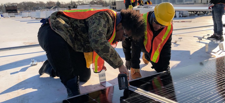 A HOPE program cohort installs solar panelling on a New York City rooftop. 